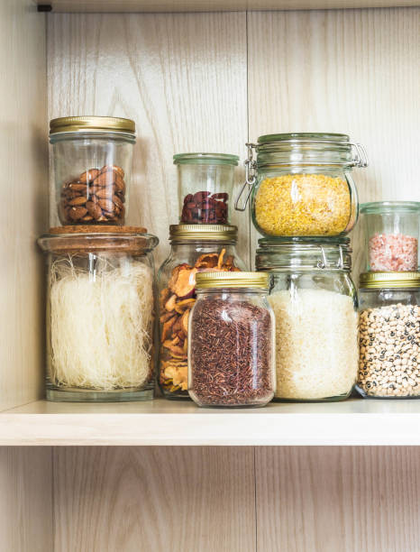 istock Shelf in the kitchen with various cereals and seeds - peas split, sunflower and pumpkin seeds, beans, rice, pasta, oatmeal, couscous, lentils, bulgur in glass jars 1212928421