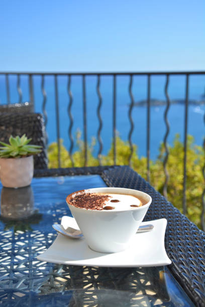 istock Cappuccino coffee in cafe with scenic sea view 1212928512