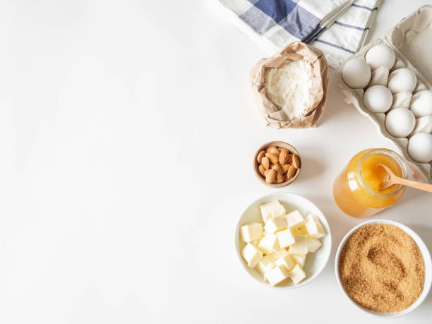 istock Set of various baking ingredients - flour, eggs, sugar, butter, honey and nuts on a white background. Top view. Copy space 1212928662