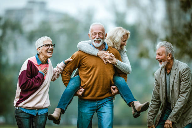 公園で秋の日に楽しんで幸せなシニアカップル。 - senior adult fun autumn senior couple ストックフォトと画像