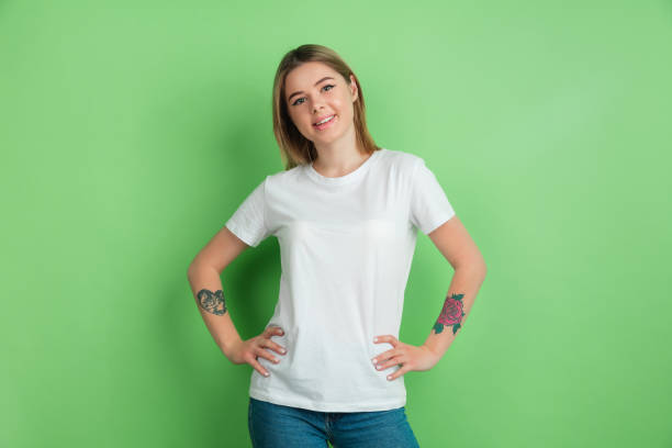 istock Caucasian young woman's portrait on green studio background 1212931904