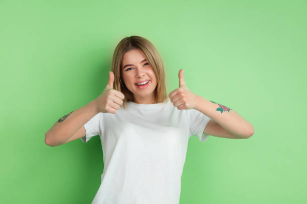 istock Caucasian young woman's portrait on green studio background 1212931928