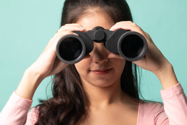 istock Young Asian woman with binoculars. 1212932272