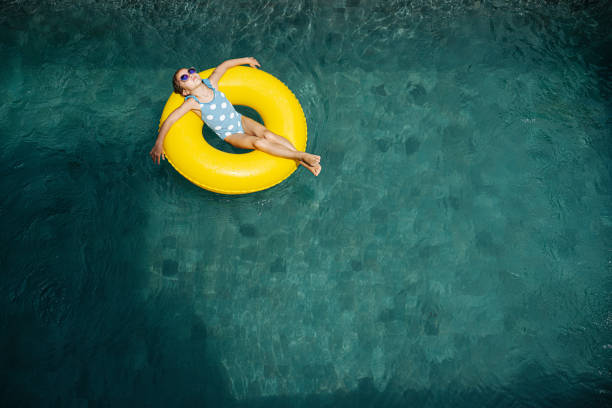 istock child relax in the pool in sunglasses lying on a yellow rubber ring 1212932909