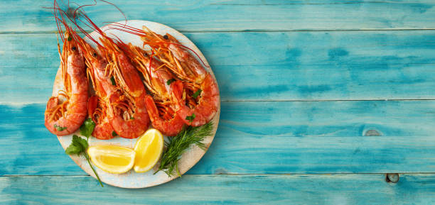 istock Top view of red big prawns on light blue background 1212933905