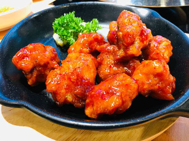istock Fried chicken mixed with Korean style sauce served in frying pan. 1212936140