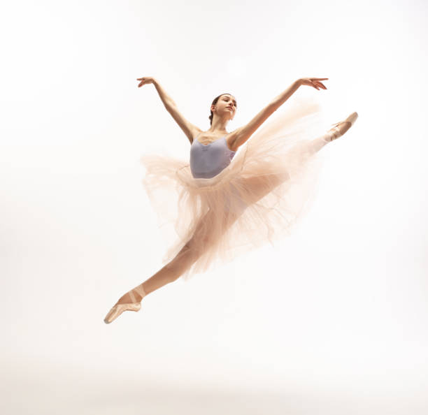 giovane graziosa ballerina tenera su sfondo studio bianco - dancer jumping ballet dancer ballet foto e immagini stock
