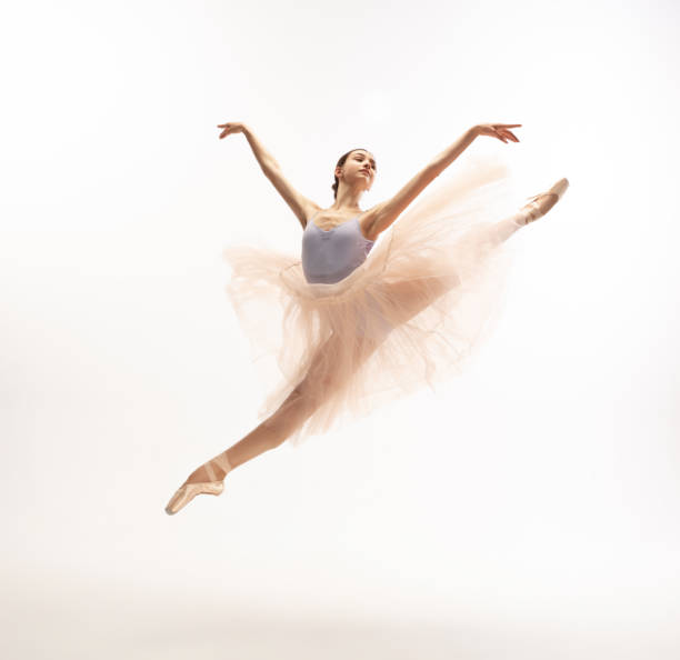 Young graceful tender ballerina on white studio background