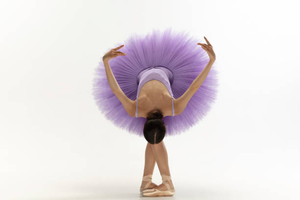 istock Young graceful tender ballerina on white studio background 1212938574