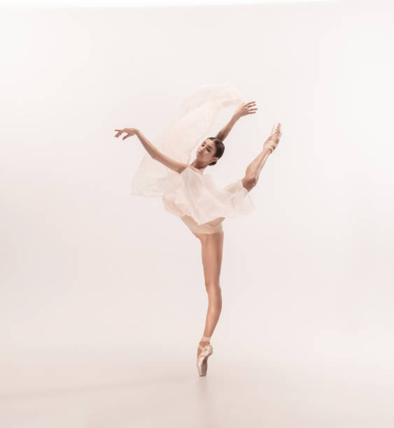 istock Young graceful tender ballerina on white studio background 1212938604