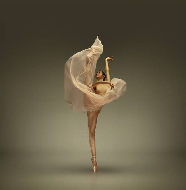 istock Young graceful tender ballerina on grey studio background 1212938651