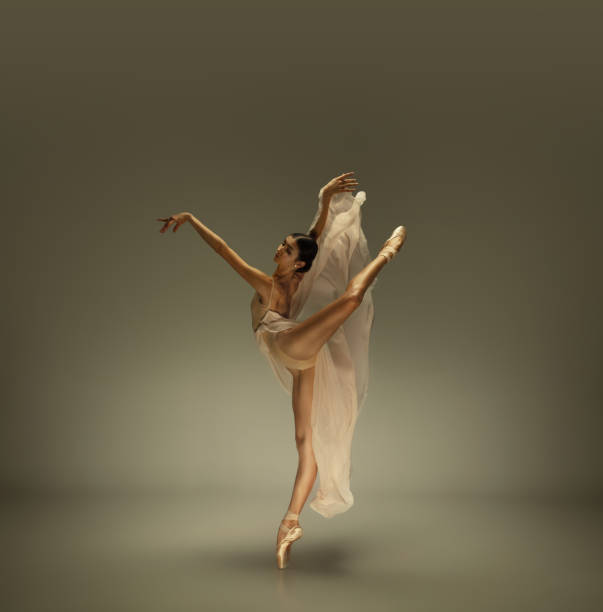 istock Young graceful tender ballerina on grey studio background 1212938656