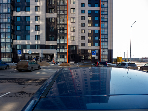 Moscow region, Russia - March 17, 2020: Apartment block front yard with parked cars