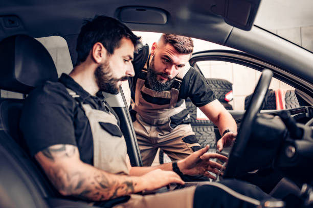 istock Two modern mechanics doing diagnostic in the car 1212943606