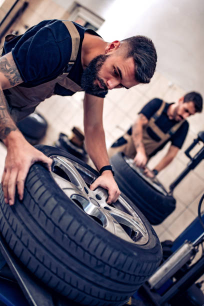 istock Two mechanics in uniform are working in auto service 1212943613
