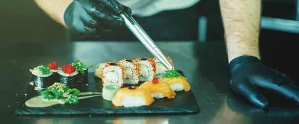 istock Photo of Chef decorating susshi and rolls in kitchen 1212943672