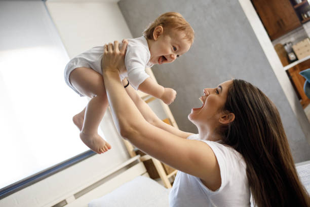 istock Mother playing with her baby boy on bed 1212945485