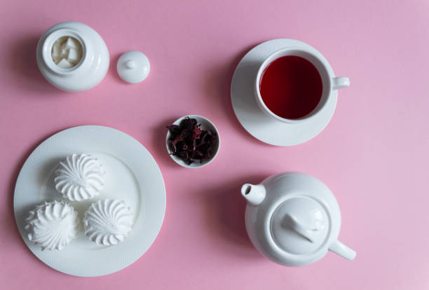 istock Marshmallow on white plate with pink hibiscus tea on red background 1212945957