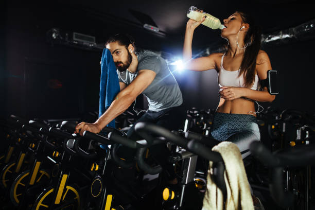 istock Young couple exhausted from working out on exercise bike 1212947809