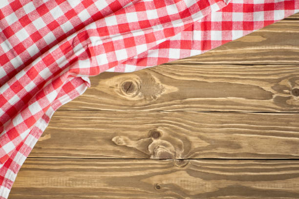 istock Red checkered tablecloth on wooden table. Background with copy space. Horizontal. Top view. 1212947876