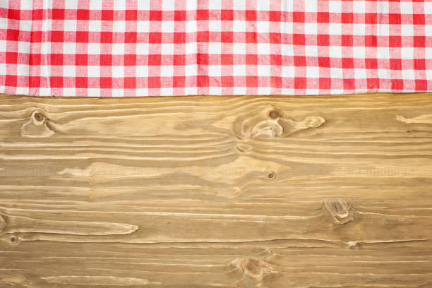 istock Red checkered tablecloth on wooden table. Background with copy space. Horizontal. Top view. 1212948428