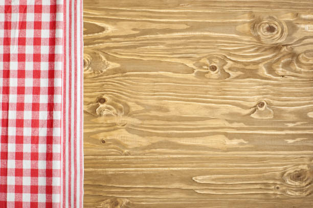 istock Red checkered tablecloth on wooden table. Background with copy space. Horizontal. Top view. 1212948451