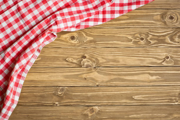 istock Red checkered tablecloth on wooden table. Background with copy space. Horizontal. Top view. 1212949166