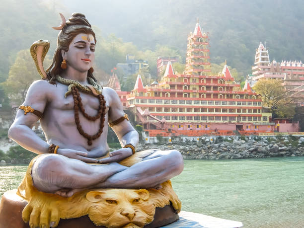 estatua de shiva sentada en meditación en la orilla del río ganga en rishikesh. - shiva fotografías e imágenes de stock