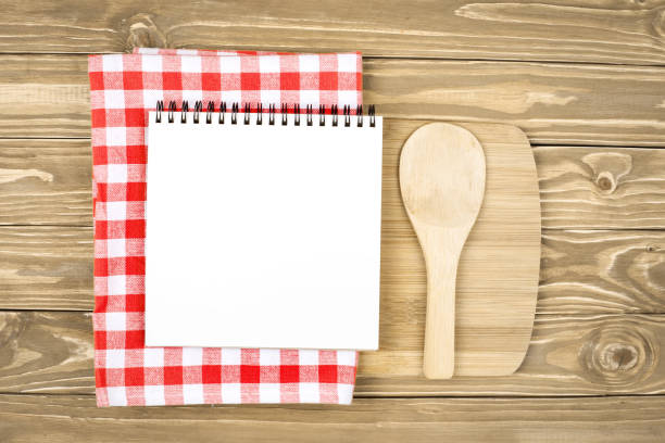 istock Blank notebook for recipes with wooden spoon on table. Background with copy space. 1212958857