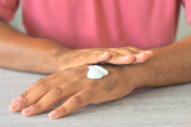 istock Man moisturising his hands with lotion 1212959262