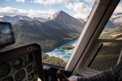 Inside of helicopter flying on rocky mountains with colorful lake in national park