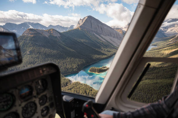 Inside of helicopter flying on rocky mountains with colorful lake stock photo