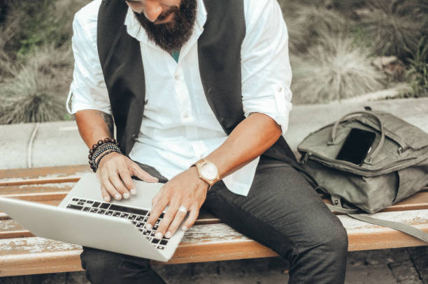 istock Young man using laptop outdoors 1212962751