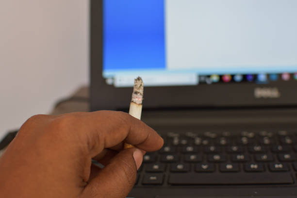 istock Smoking cigarette on the desk with laptop computer. Smoking to relieve stress at work but unhealthy 1212962907