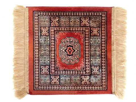 Elegant small red Persian rug with fringe isolated on white background.