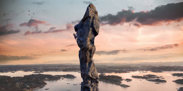 istock Female Climber Ascends High Altitude Coastal Rock Column At Sunrise 1212965979