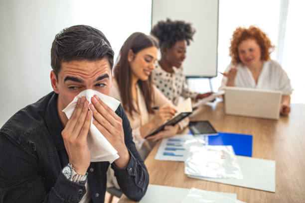 istock Shot of a young man blowing his nose while working. 1212967520