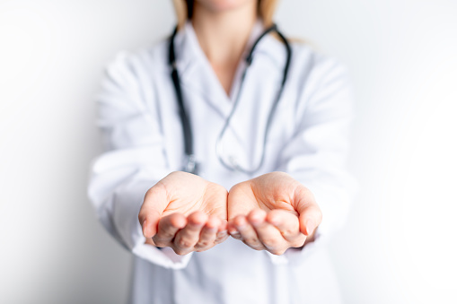 Female doctor presenting blank palm of her hand holding something copy space