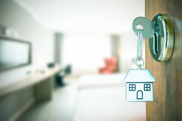 istock home key with house keyring in the door keyhole. 1212969331