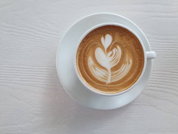 istock Top view latte art coffee on white wooden background 1212970941