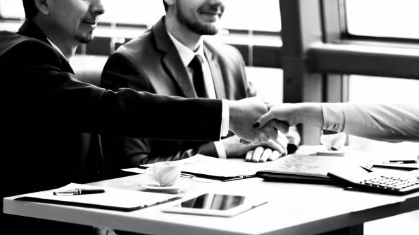 istock handshake Manager and the client over a Desk 1212973177