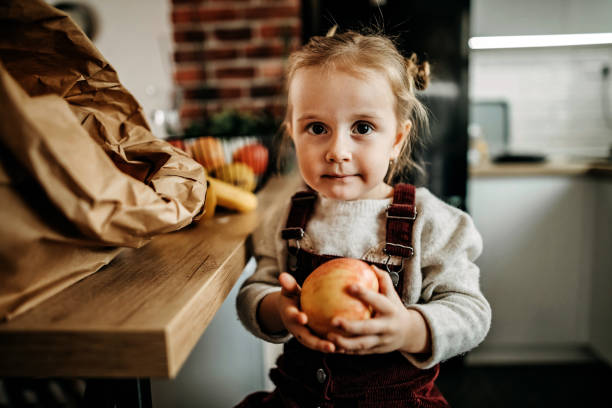 istock Kid eating fruits in kitchen 1212976837