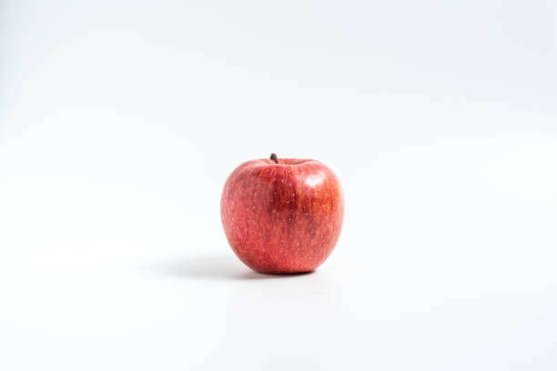 istock Holding an apple in the hand from below isolated on white background 1212981026
