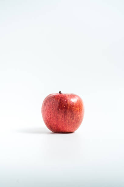 istock Holding an apple in the hand from below isolated on white background 1212981200