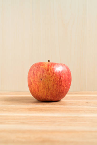 sosteniendo una manzana en la mano desde abajo aislada sobre fondo blanco - single hit fotografías e imágenes de stock