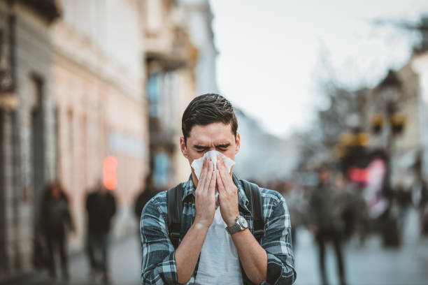 istock Cold and flu. Man blowing his nose with a tissue 1212983078