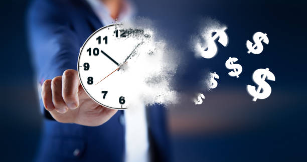 istock man hand clock with dollar sign in screen 1212983138