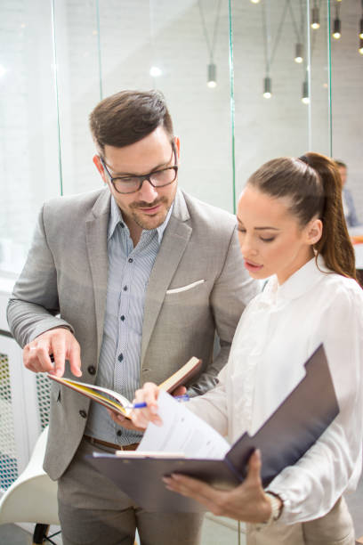 istock Business people discussing document in office lobby. 1212983268