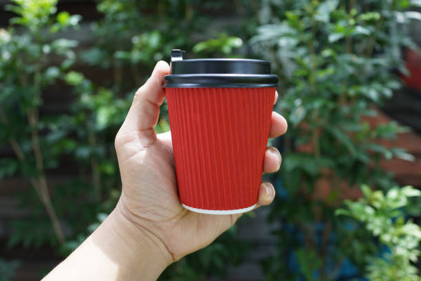 istock Hand holding a paper coffee cup 1212984396