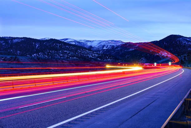 Interstate 70 Colorado Driving Time Exposure - Vehicles creating light streaks during long exposure at dusk during blue hour. Red and white lights creating light trails. Entering Glenwood Canyon, Colorado USA.